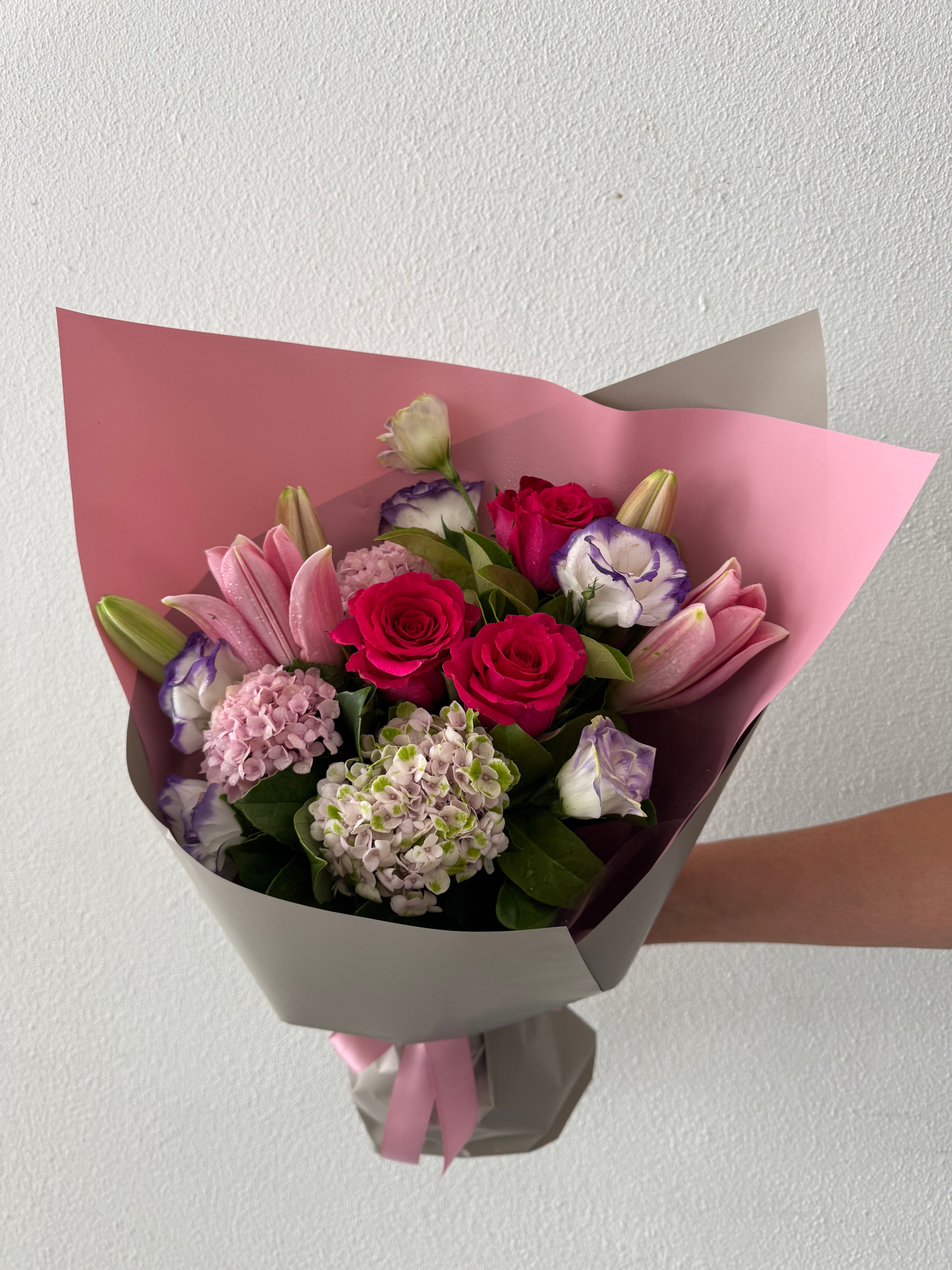 A bouquet of flowers with pink, red, white, and purple flowers
