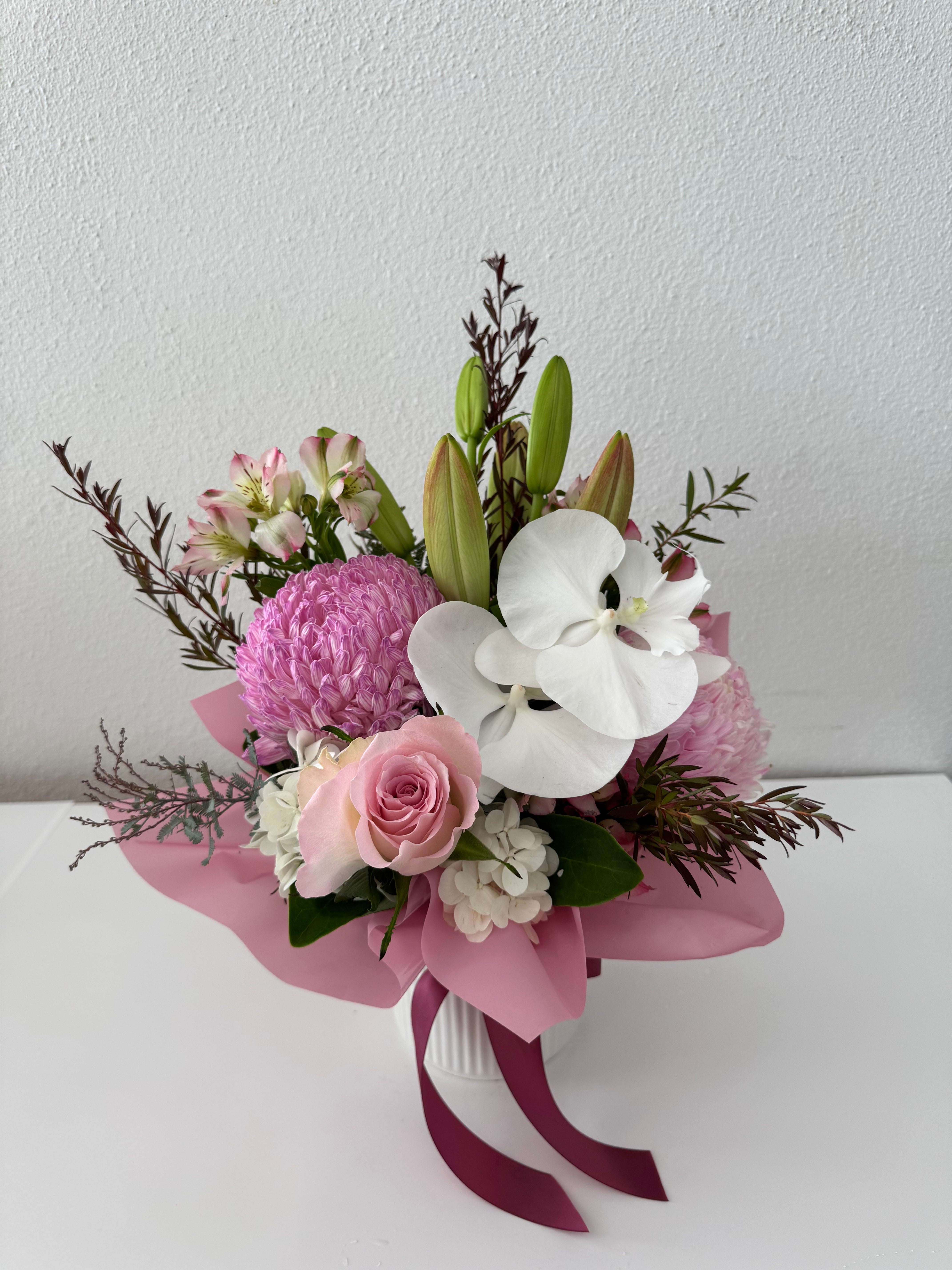 Jasmin-A ceramic pot with a bouquet of pink and white flowers