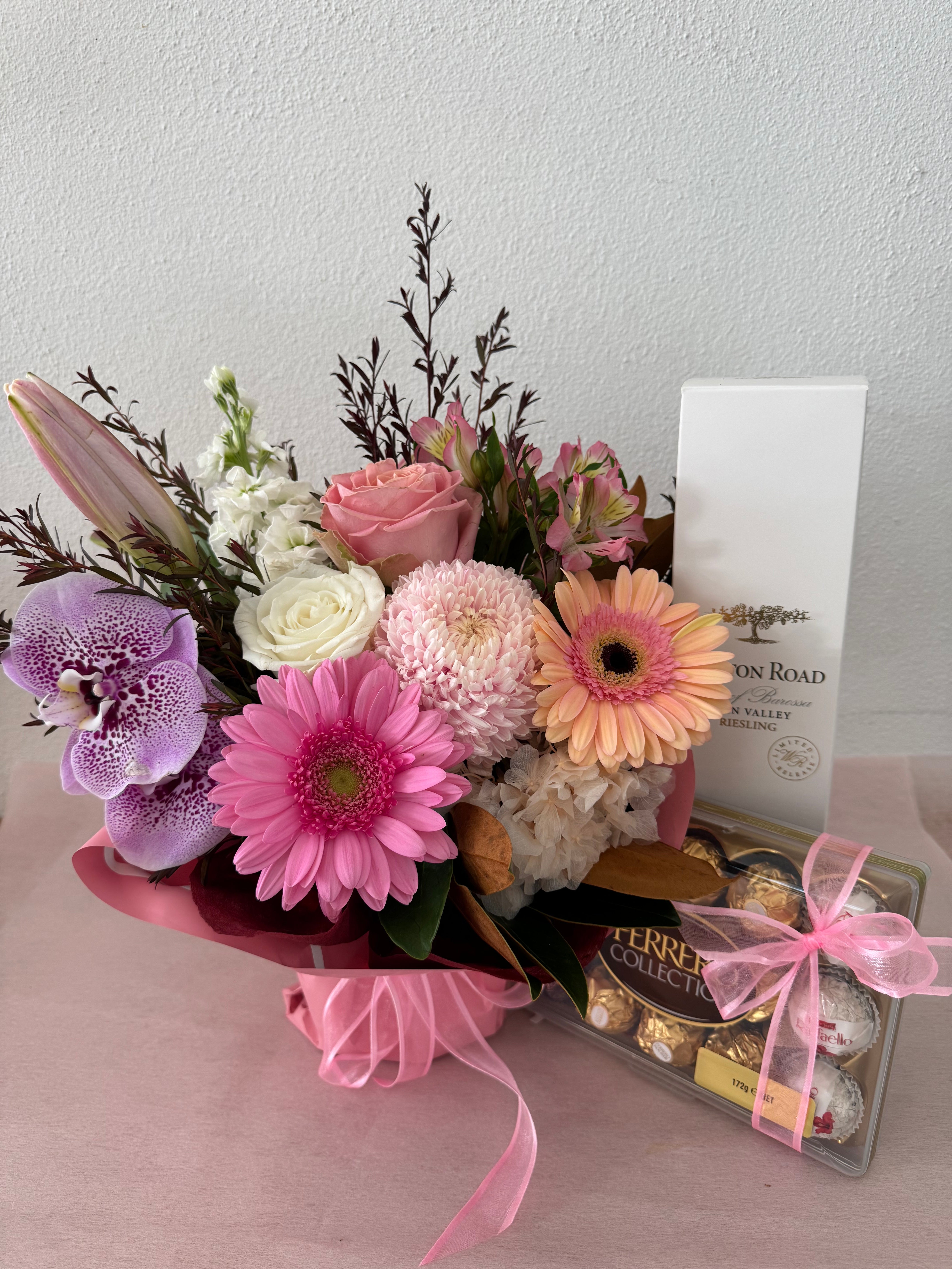 A flower bouquet with chocolates and card