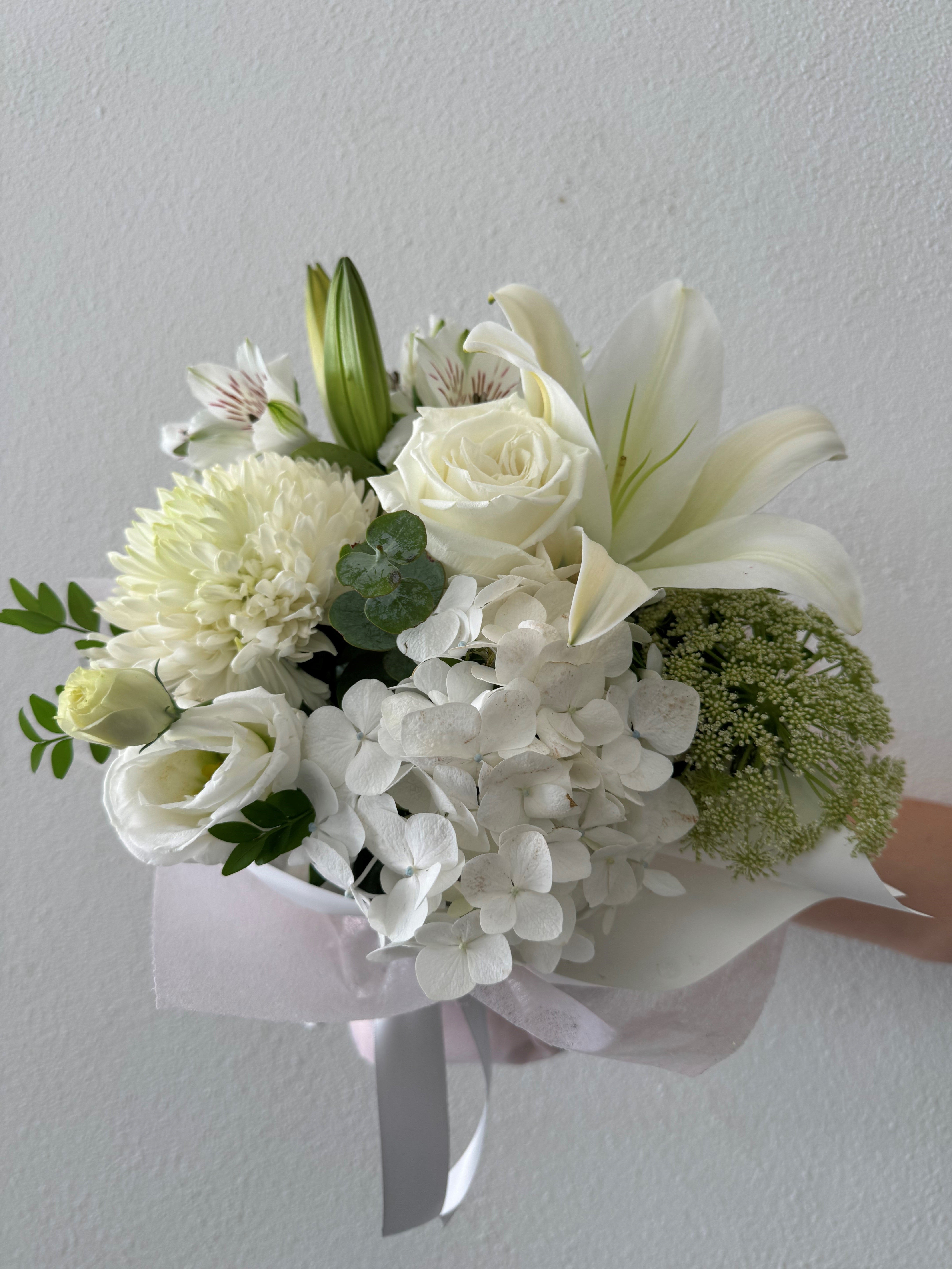 A bouquet of white and green flowers including roses and orchids
