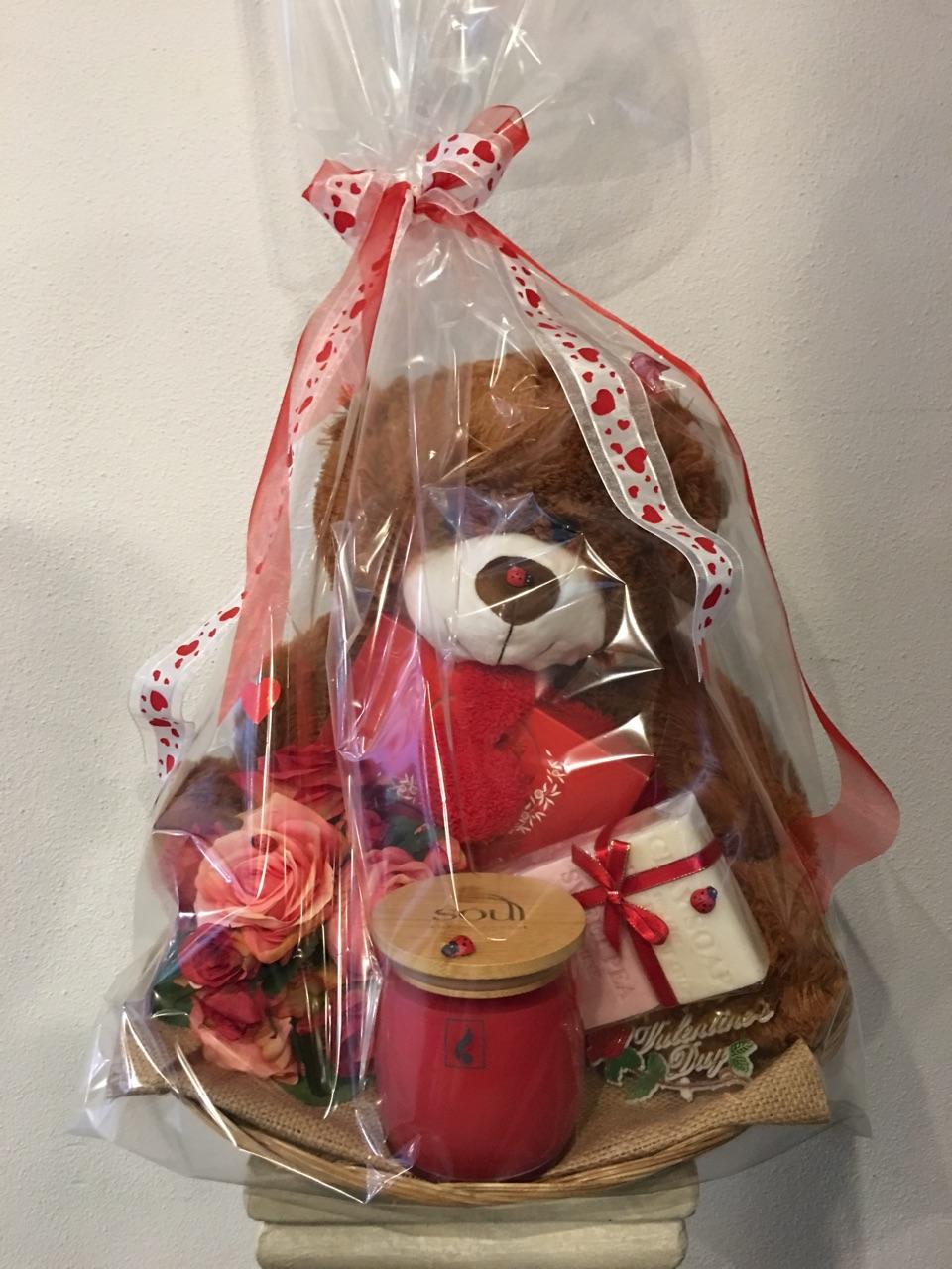 A luxury Valentine's Day hamper gift set including a teddy bear, chocolates, a candle, a soap set, and silk flowers